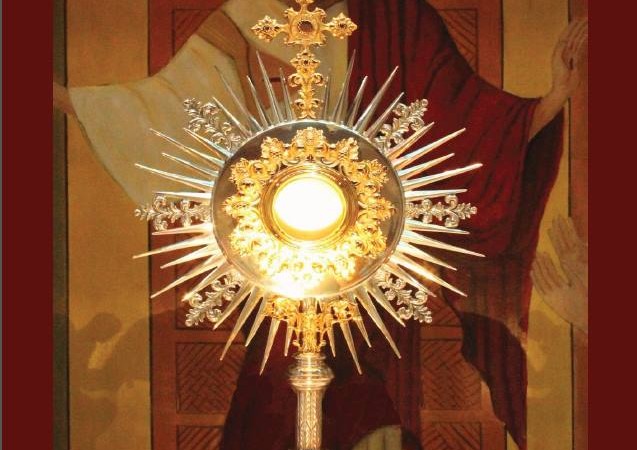 Imagen de la eucaristía con el Sagrado Corazón de fondo