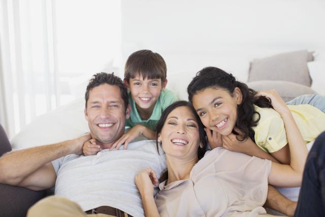 Family smiling together on sofa in living room